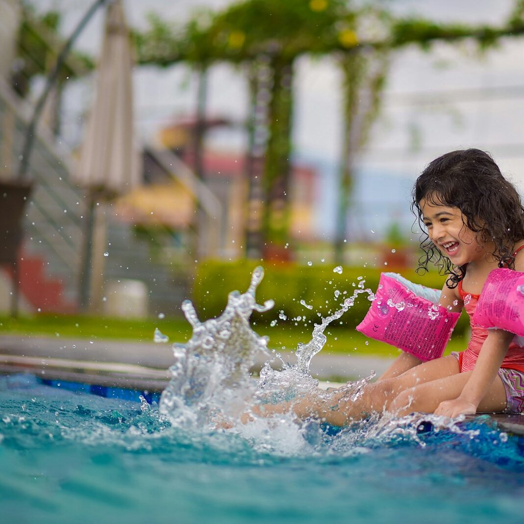 girl in pink shirt on swimming pool during daytime